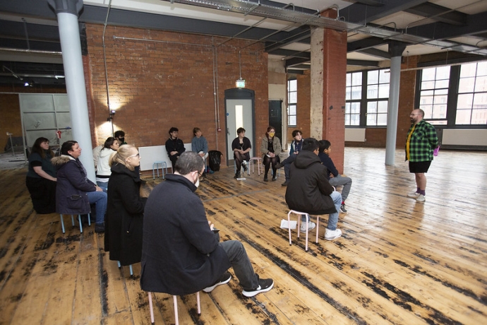 Bolton students sat in a circle in a gallery space listening to a creative practitioner deliver a workshop